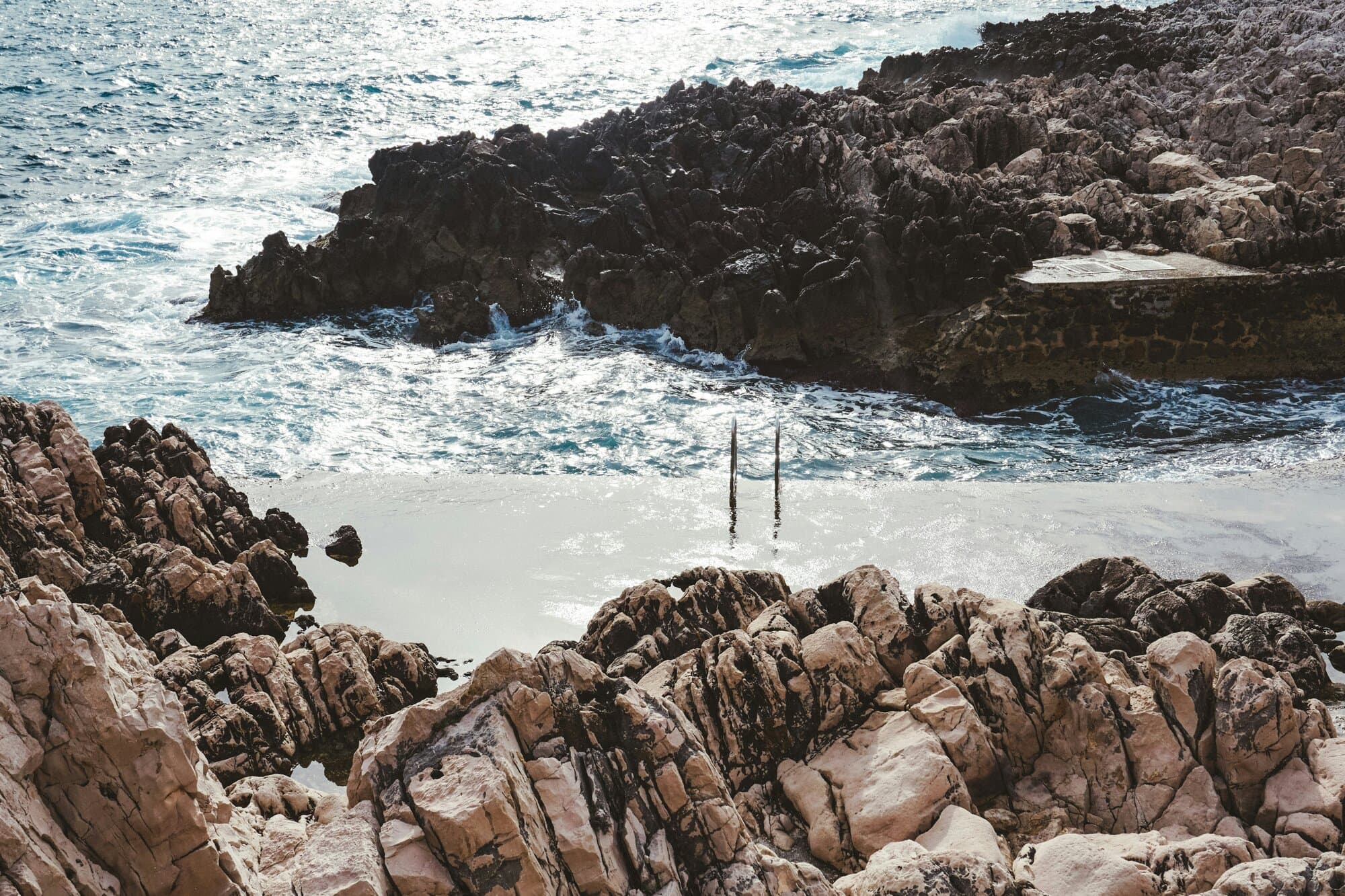 Mediterranean rocky coastline along the western bay near Cannes — the cinematic register the Riviera has worn on film since the 1950s.